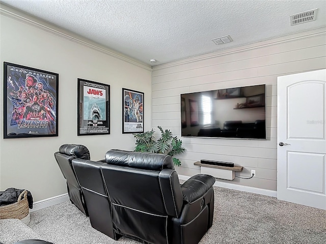 carpeted cinema room featuring wooden walls, visible vents, baseboards, and crown molding