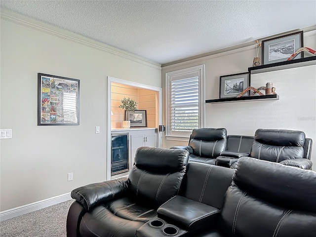 cinema room featuring baseboards, ornamental molding, a textured ceiling, carpet, and beverage cooler