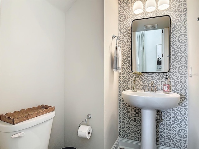 half bath featuring visible vents and toilet