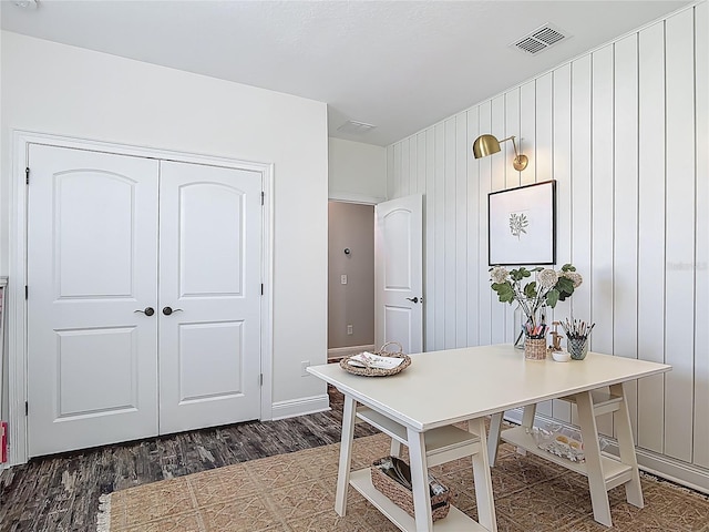 office featuring dark wood-type flooring, visible vents, and baseboards