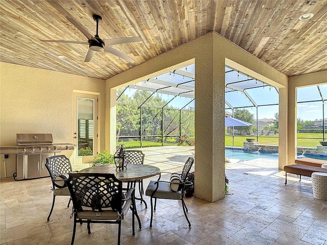 view of patio / terrace featuring ceiling fan, an outdoor pool, exterior kitchen, a lanai, and outdoor dining area