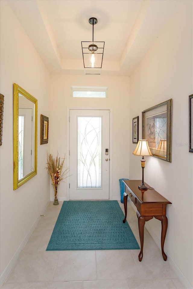 6960 Audobon Osprey Cv, Harmony, FL 34773 - foyer featuring light tile patterned floors, a tray ceiling, and baseboards