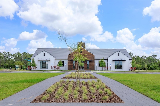 6960 Audobon Osprey Cv, Harmony, FL 34773 - modern farmhouse style home featuring a front yard, metal roof, and a standing seam roof