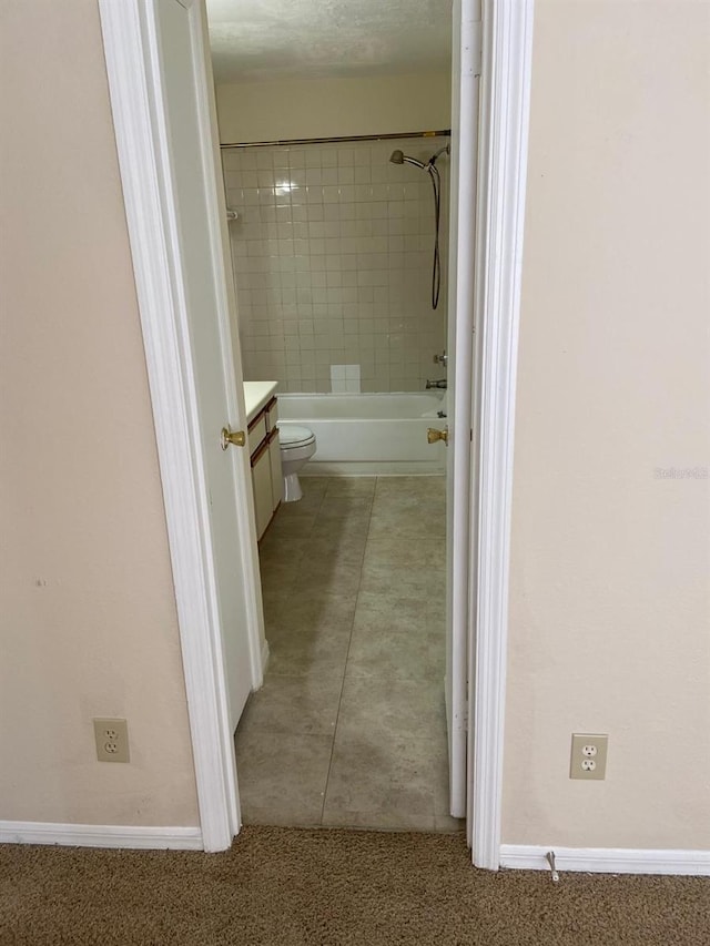 full bath featuring toilet, vanity, and baseboards