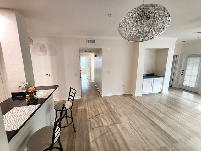 2528 Robert Trent Jones Dr Unit 1617, Orlando, FL 32835 - dining space featuring visible vents, baseboards, ornamental molding, a chandelier, and light wood-style flooring