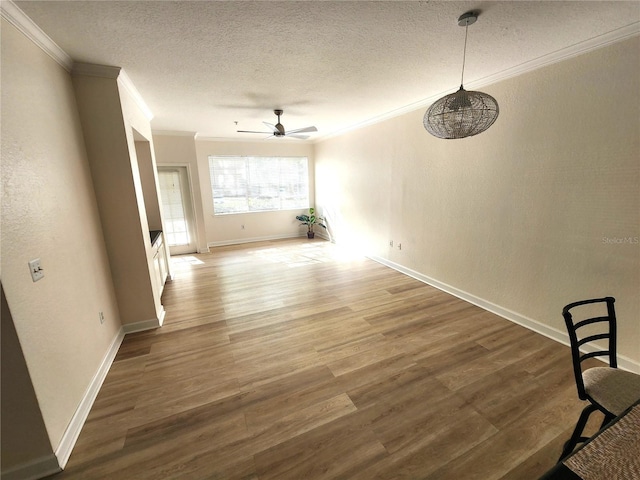 2528 Robert Trent Jones Dr Unit 1617, Orlando, FL 32835 - unfurnished dining area with baseboards, a textured ceiling, crown molding, ceiling fan, and wood finished floors