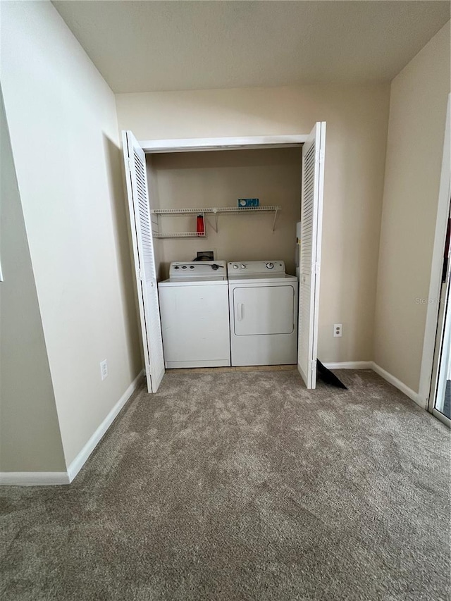 clothes washing area with washing machine and clothes dryer, laundry area, baseboards, and carpet flooring