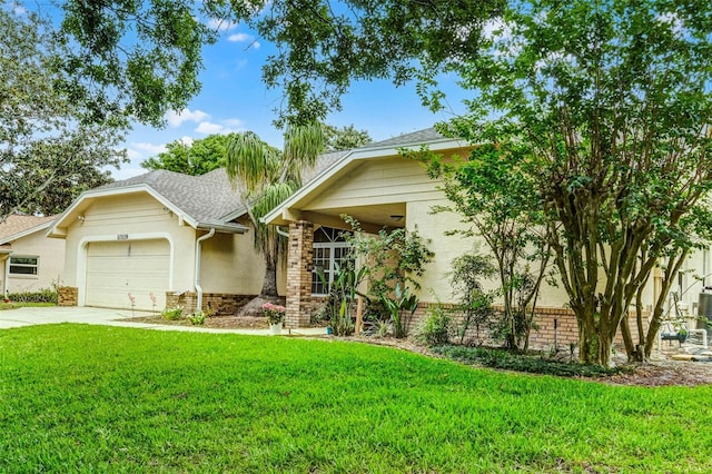 view of front of property featuring stucco siding, driveway, a front yard, brick siding, and a garage