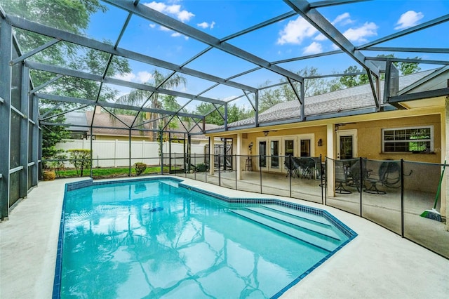 view of swimming pool with fence, glass enclosure, a patio, french doors, and a fenced in pool