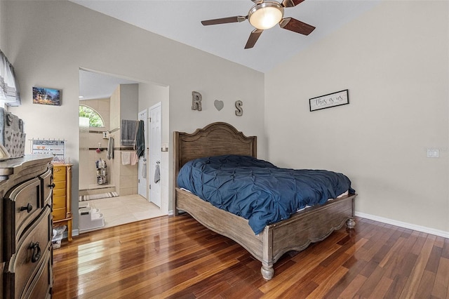 bedroom with baseboards, ensuite bath, a ceiling fan, lofted ceiling, and hardwood / wood-style flooring