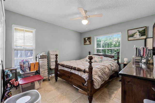 bedroom with ceiling fan and a textured ceiling