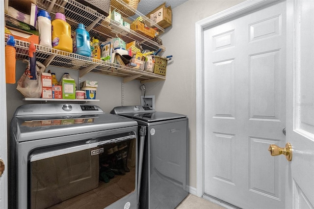 laundry room with baseboards, washing machine and dryer, and laundry area