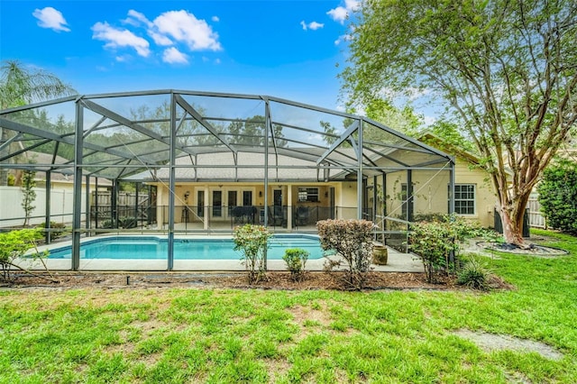 back of house with a fenced in pool, stucco siding, glass enclosure, fence, and a lawn