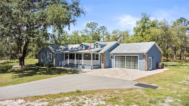 6330 Oil Well Rd, Clermont, FL 34714 - view of front of house featuring a front yard, driveway, an attached garage, and covered porch