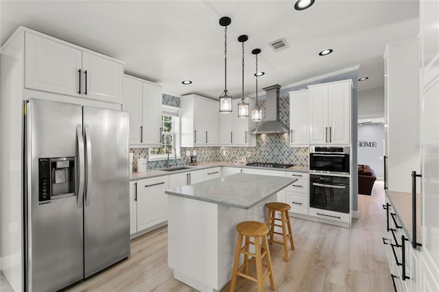 6330 Oil Well Rd, Clermont, FL 34714 - kitchen featuring wall chimney range hood, visible vents, a kitchen island, a sink, and stainless steel appliances