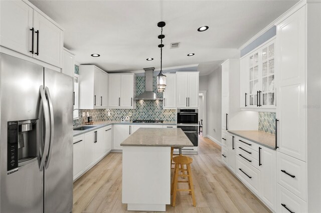 6330 Oil Well Rd, Clermont, FL 34714 - kitchen with wall chimney range hood, a kitchen island, a breakfast bar, recessed lighting, and appliances with stainless steel finishes