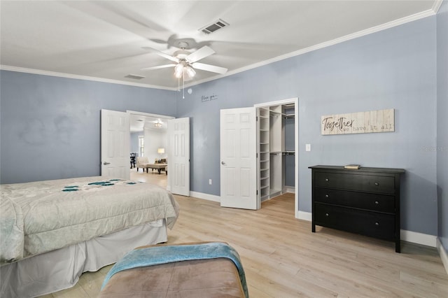 6330 Oil Well Rd, Clermont, FL 34714 - bedroom featuring crown molding, light wood-style flooring, visible vents, a walk in closet, and baseboards