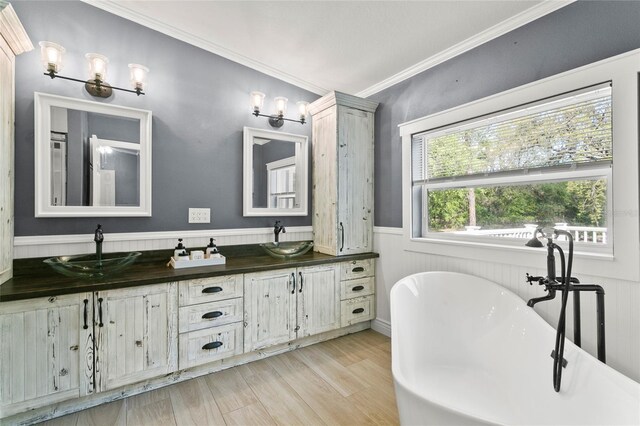 6330 Oil Well Rd, Clermont, FL 34714 - bathroom featuring a freestanding bath, a sink, crown molding, wood finished floors, and a wainscoted wall