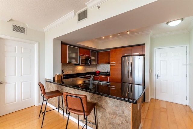 2030 S Douglas Rd Unit 718, Coral Gables, FL 33134 - kitchen with stainless steel appliances, crown molding, light wood-style flooring, tasteful backsplash, and a peninsula