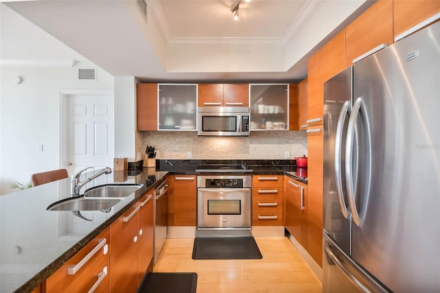 2030 S Douglas Rd Unit 718, Coral Gables, FL 33134 - kitchen with stainless steel appliances, crown molding, a tray ceiling, brown cabinets, and tasteful backsplash