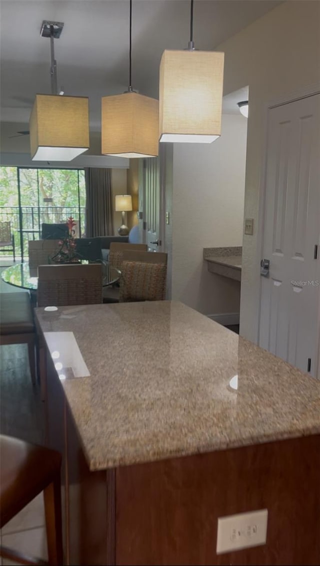 12527 Floridays Resort Dr Unit 311E, Orlando, FL 32821 - kitchen with stone counters and hanging light fixtures