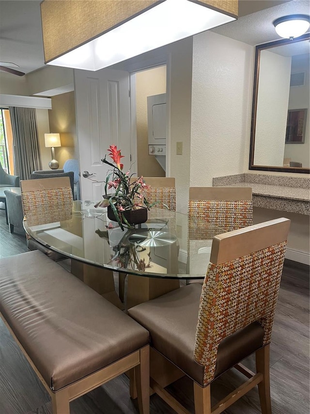 12527 Floridays Resort Dr Unit 311E, Orlando, FL 32821 - dining space featuring stacked washing maching and dryer, visible vents, baseboards, and wood finished floors