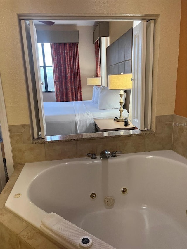 12527 Floridays Resort Dr Unit 311E, Orlando, FL 32821 - full bath featuring a jetted tub and a textured wall