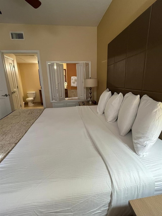 12527 Floridays Resort Dr Unit 311E, Orlando, FL 32821 - bedroom with visible vents, ceiling fan, and ensuite bathroom
