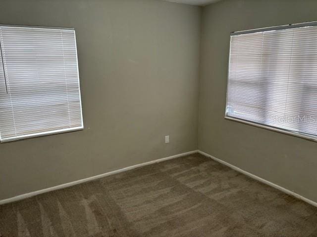 160 S Oxalis Dr, Orlando, FL 32807 - spare room featuring dark carpet and baseboards
