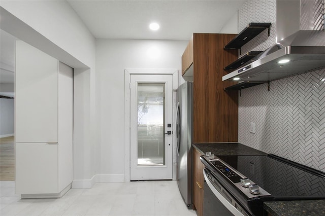 kitchen featuring dark countertops, wall chimney exhaust hood, modern cabinets, and stainless steel appliances