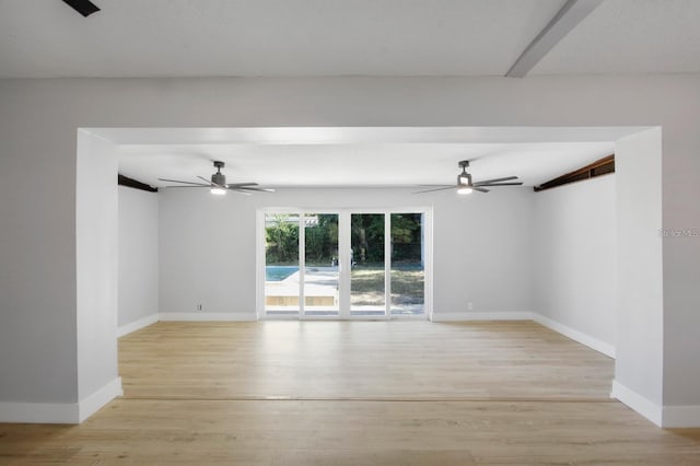 unfurnished room with beam ceiling, baseboards, a ceiling fan, and light wood-style floors