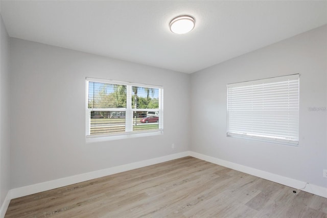 empty room featuring light wood-style floors and baseboards