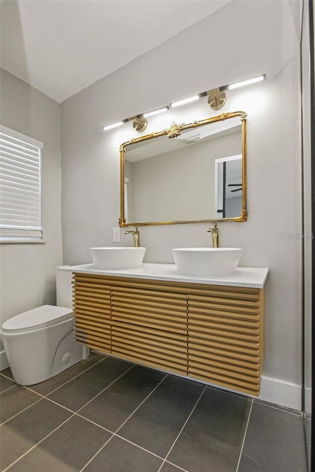 full bath with double vanity, a sink, and tile patterned flooring