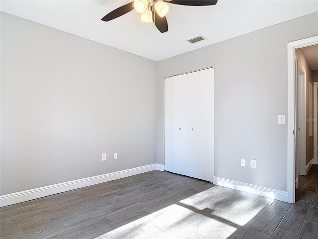 unfurnished bedroom featuring baseboards, wood finished floors, visible vents, and a closet