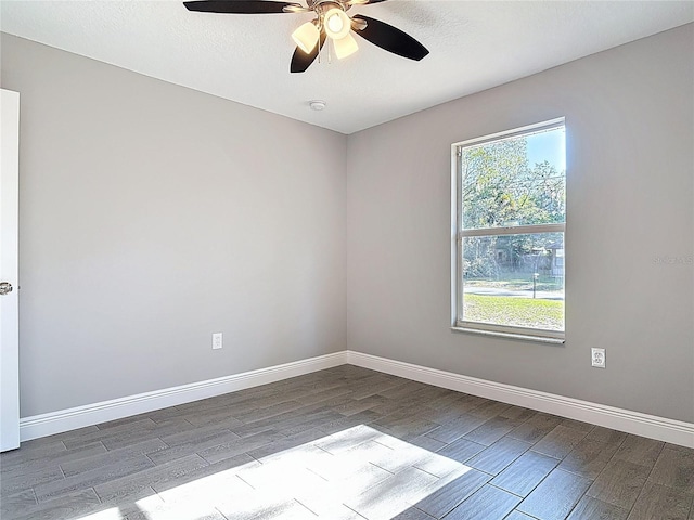 empty room featuring wood finish floors, a ceiling fan, and baseboards