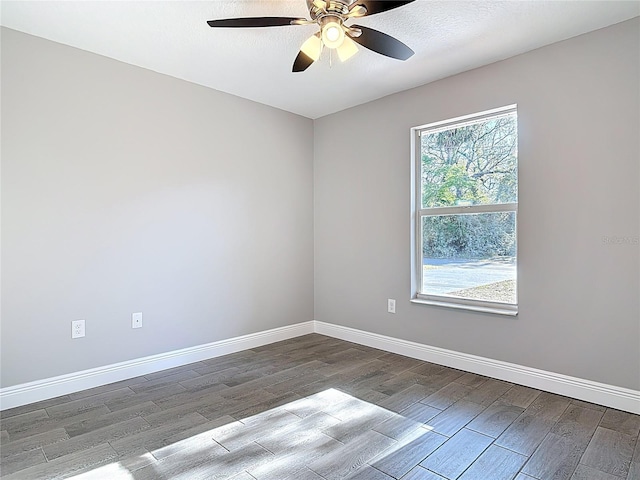 spare room with wood finished floors, baseboards, and ceiling fan