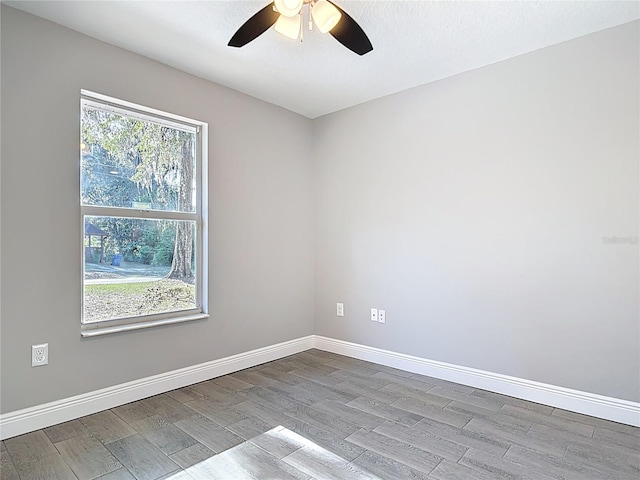 unfurnished room with baseboards, a ceiling fan, and wood finished floors