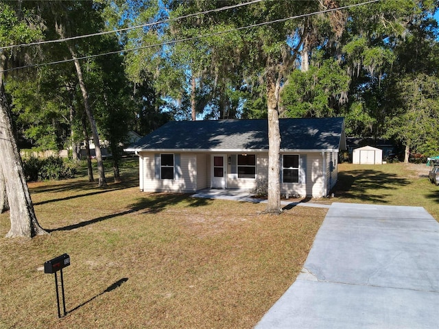 view of front of property with an outbuilding, a storage shed, and a front yard
