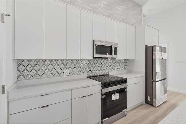 2551 Alhaven Ter, North Port, FL 34286 - kitchen with light wood finished floors, stainless steel appliances, decorative backsplash, light stone counters, and white cabinetry