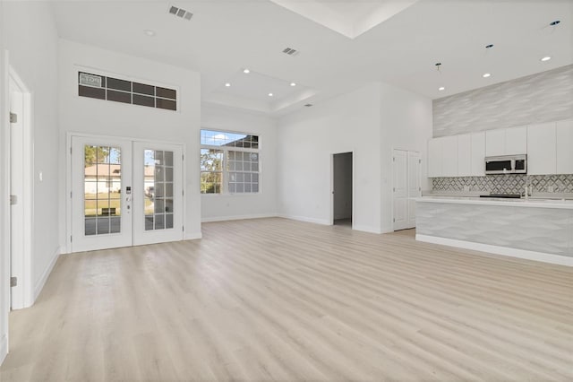 2551 Alhaven Ter, North Port, FL 34286 - unfurnished living room featuring a high ceiling, light wood-style flooring, and baseboards