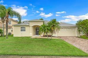 5005 Cape Hatteras Dr, Clermont, FL 34714 - view of front of house with driveway, stucco siding, and a front lawn