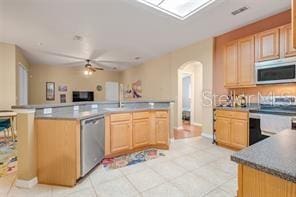 5005 Cape Hatteras Dr, Clermont, FL 34714 - kitchen with stove, arched walkways, a ceiling fan, dishwasher, and light brown cabinets