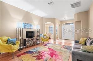 5005 Cape Hatteras Dr, Clermont, FL 34714 - living area with visible vents, arched walkways, and wood finished floors