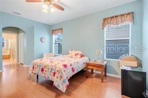 5005 Cape Hatteras Dr, Clermont, FL 34714 - bedroom featuring arched walkways, wood finished floors, and baseboards