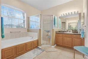 5005 Cape Hatteras Dr, Clermont, FL 34714 - full bathroom with tile patterned flooring, vanity, a bath, and a stall shower