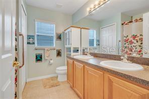 5005 Cape Hatteras Dr, Clermont, FL 34714 - full bathroom with toilet, tile patterned floors, double vanity, and a sink