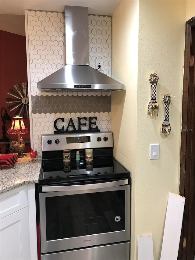 kitchen with white cabinetry, backsplash, stainless steel electric stove, and wall chimney exhaust hood