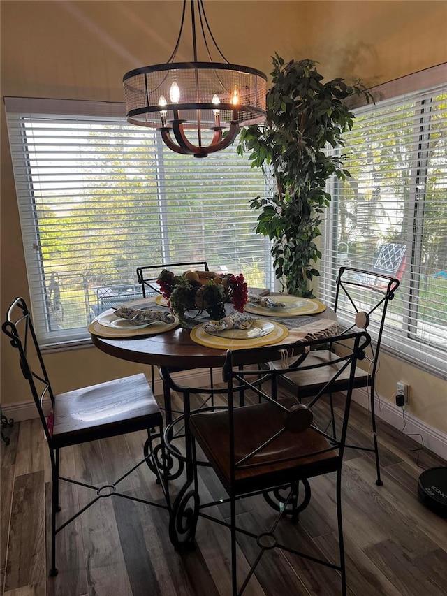 dining area with baseboards, a notable chandelier, and wood finished floors