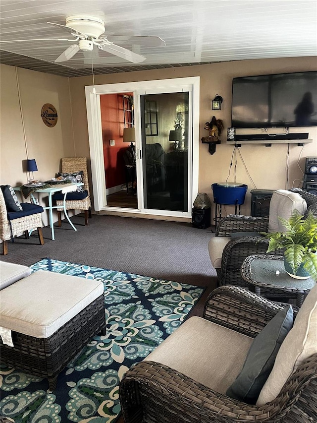 carpeted living area with a ceiling fan