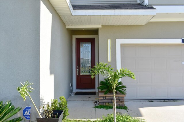 184 Lake Smart Cir, Winter Haven, FL 33881 - view of exterior entry featuring stucco siding and a garage